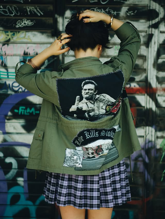 Modelo de espaldas con chamarra militar parchada de Johnny Cash