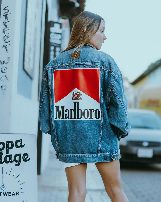 Modelo con chamarra de mezclilla oversize gráfica Marlboro en la calle